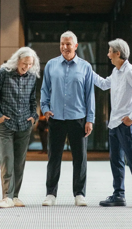 three people wearing button down shirts with magnetic buttons and side zip pants from Joe & Bella