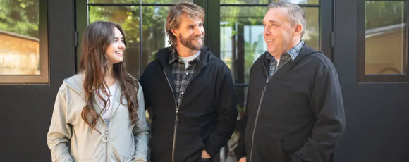 three people wearing a zip-up hoodie from Joe & Bella