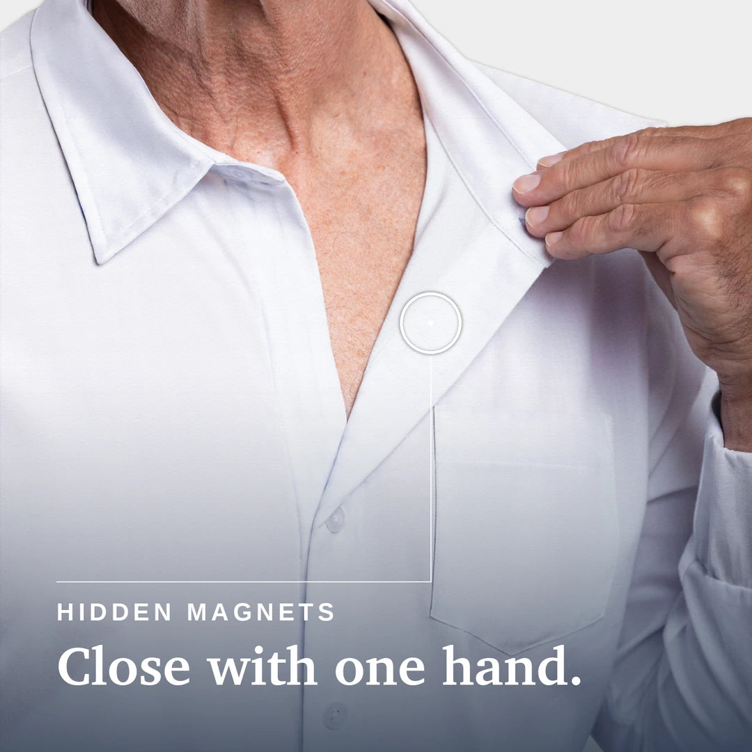 Close-up of a person wearing a white button-up shirt, with one hand pulling the collar slightly open. Text on the image reads 'HIDDEN MAGNETS Close with one hand. Joe & Bella Magnetic Button-Down for Men | Relaxed-Fit #White