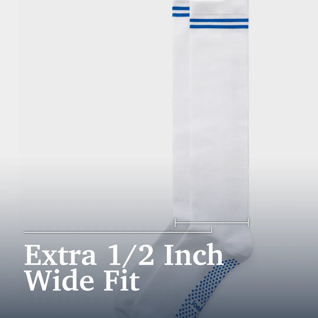 ["A single white sock shown against a light gray gradient background with text reading 'Extra 1/2 Inch Wide Fit.' The sock has two blue horizontal stripes near the top and a blue dotted pattern near the foot. Joe & Bella Big-Grip No-Slip Compression Socks: 3-Pack ", "White"]