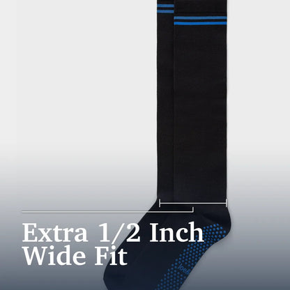 A single black wide-fit sock shown against a light gray gradient background with white text reading 'Extra 1/2 Inch Wide Fit' and a measurement bracket indicating the width. The sock has blue horizontal stripes near the top and a blue dotted grip pattern on the sole. Joe & Bella Big-Grip No-Slip Compression Socks: 3-Pack #Black