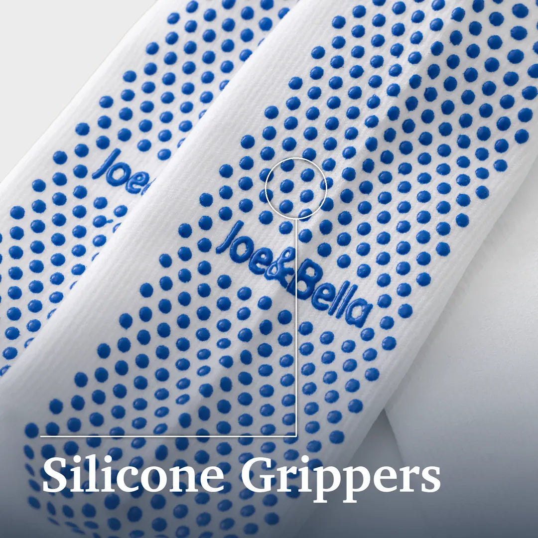 ["Close-up of a white textured strap or band with repeated blue silicone grippers and blue 'Joe&Bella' branding, plus large text reading 'Silicone Grippers' at the bottom. Joe & Bella Big-Grip No-Slip Compression Socks: 3-Pack ", "White"]