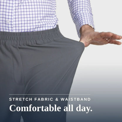 A close-up of a person wearing gray elastic-waist pants, pulling the fabric outward with one hand to demonstrate stretch. The person is also wearing a blue and white checkered shirt. Joe & Bella CareZips® Men's Access Pants #Slate Grey