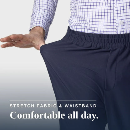A close-up of a person wearing dark navy elastic-waist pants and a white button-up shirt with a blue grid pattern, stretching the fabric of the pants to demonstrate elasticity. White text at the bottom reads 'STRETCH FABRIC & WAISTBAND' and 'Comfortable all day. Joe & Bella CareZips® Men's Access Pants #Dark Navy