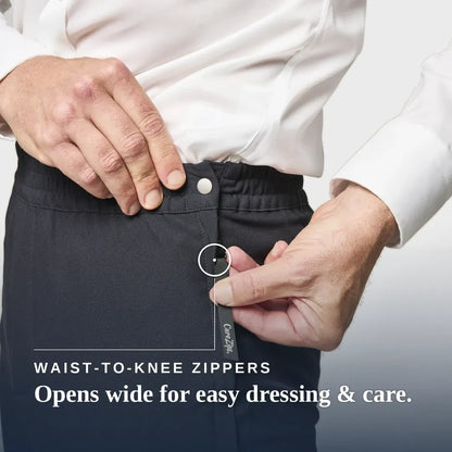 Close-up of a person wearing dark charcoal knee-high compression or medical pants, demonstrating a waist-to-knee zipper that opens wide. The person is wearing a white dress shirt. Joe & Bella CareZips® Men's Adaptive Pants #Black
