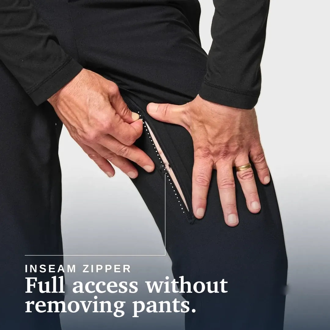 Close-up of a person wearing black pants and pulling open an inseam zipper with both hands, with text reading 'INSEAM ZIPPER' and 'Full access without removing pants.'. Joe & Bella CareZips® Men's Adaptive Pants #Black