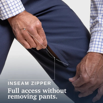 Close-up of a person's hands demonstrating the inside zippered inseam of navy pants, with text overlay reading 'INSEAM ZIPPER Full access without removing pants.'. Joe & Bella CareZips® Men's Access Pants #Dark Navy