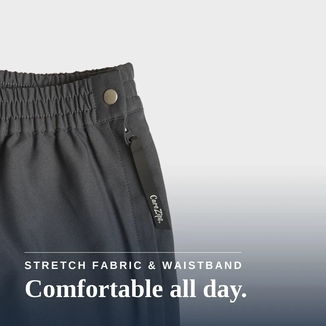 ["Close-up of dark charcoal gray athletic pants showing the elastic waistband with a metal snap button and a fabric drawstring tag. White text at the bottom reads 'STRETCH FABRIC & WAISTBAND' and 'Comfortable all day. Joe & Bella CareZips® Women's Access Pants ", "Grey"]