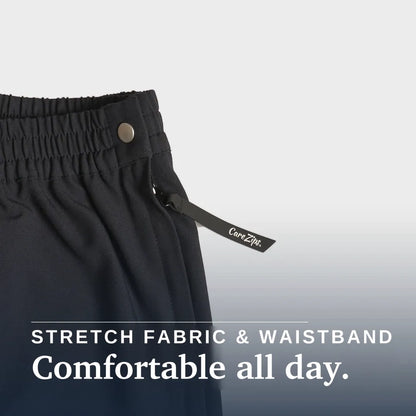 Close-up of dark charcoal gray or black athletic pants showing the elastic waistband, a metal snap button, and a drawstring with a visible CareZip tag. Text overlay at the bottom reads 'STRETCH FABRIC & WAISTBAND Comfortable all day. Joe & Bella Black / XS CareZips® Women's Adaptive Pants #Black