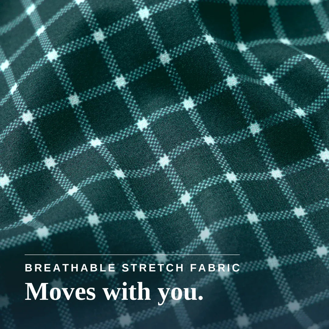 Close-up of a dark green plaid fabric with a white grid pattern and a white button on the cuff, with text reading 'BREATHABLE STRETCH FABRIC Moves with you.'. Joe & Bella Everyday Magnetic Button-Down for Men | Tailored-Fit#Green Check