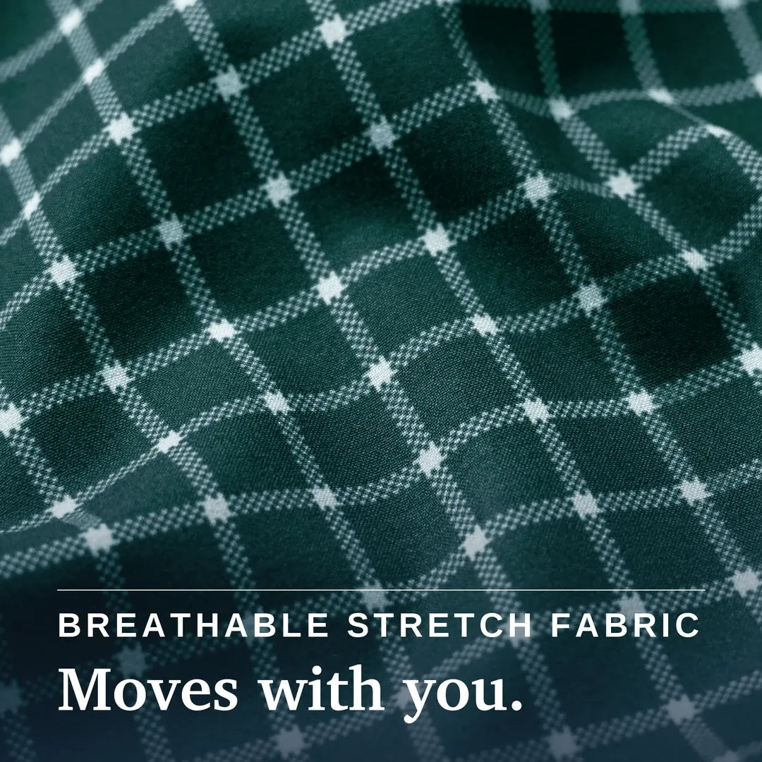 Close-up of a dark green plaid fabric with a white grid pattern and a white button on the cuff, with text reading 'BREATHABLE STRETCH FABRIC Moves with you.'. Joe & Bella Everyday Magnetic Button-Down for Men | Tailored-Fit#Green Check