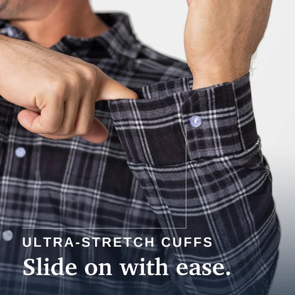 Close-up of a man's hand adjusting the cuff of a black and gray plaid button-up shirt, with text reading 'ULTRA-STRETCH CUFFS Slide on with ease.'. Joe & Bella Everyday Magnetic Flannel for Men #Black Plaid