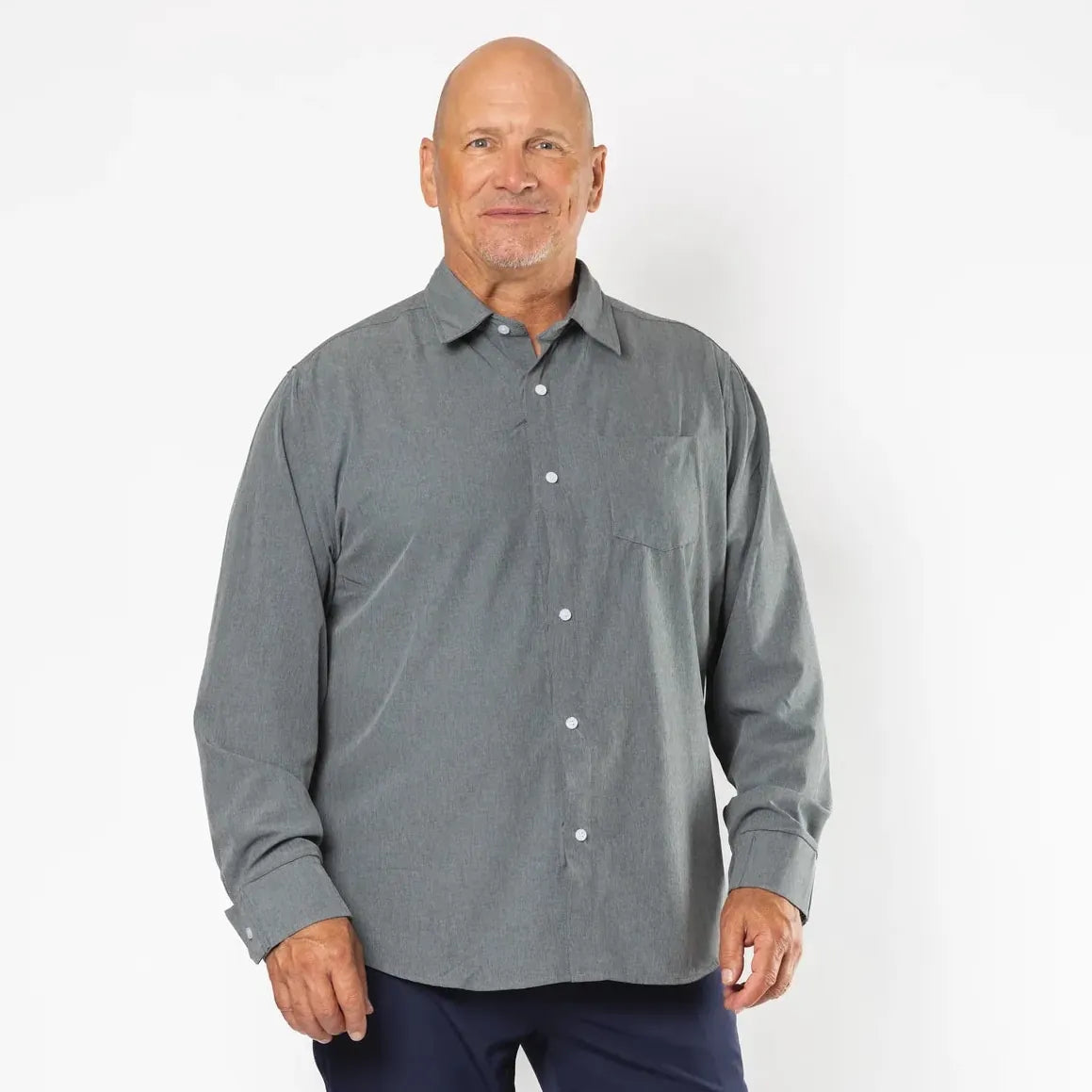 A man modeling a gray long-sleeve button-down shirt and navy blue pants against a plain white studio background. Joe & Bella Everyday Magnetic Button-Down for Men | Relaxed-Fit #Heathered Grey