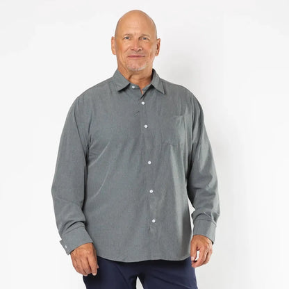 A man modeling a gray long-sleeve button-down shirt and navy blue pants against a plain white studio background. Joe & Bella Everyday Magnetic Button-Down for Men | Relaxed-Fit #Heathered Grey