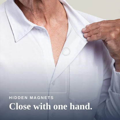 Close-up of a person wearing a white button-up shirt, with one hand pulling the collar slightly open. Text on the image reads 'HIDDEN MAGNETS Close with one hand. Joe & Bella Magnetic Button-Down for Men | Relaxed-Fit #White