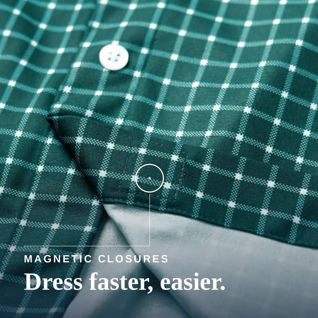 Close-up of a green and white plaid button-up shirt with a folded cuff showing a gray inner lining and magnetic closure detail, with text reading 'MAGNETIC CLOSURES Dress faster, easier.'. Joe & Bella Everyday Magnetic Button-Down for Men | Relaxed-Fit#Green Check
