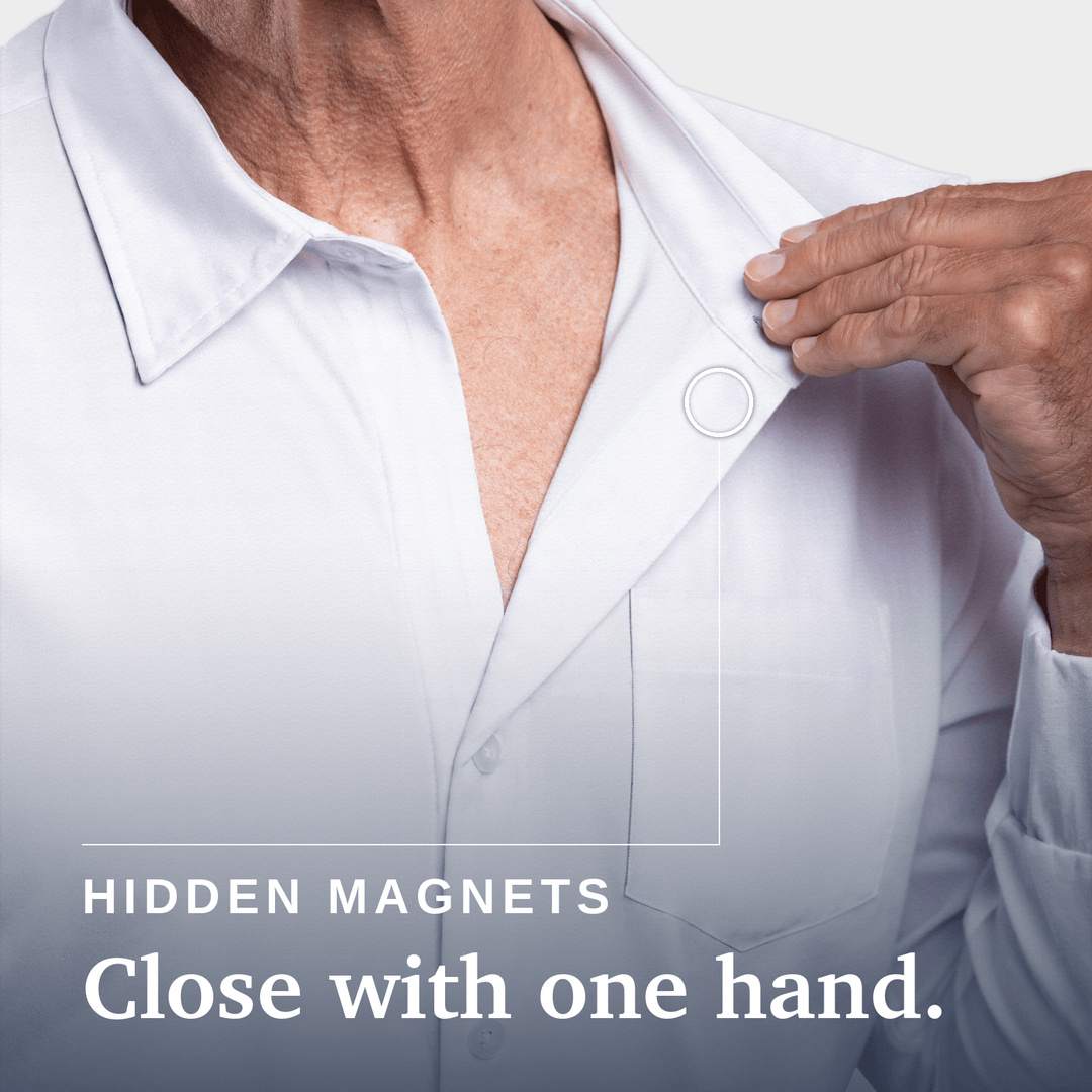 Close-up of a person wearing a white button-up shirt, with one hand pulling the collar slightly open. Text on the image reads 'HIDDEN MAGNETS Close with one hand. Joe & Bella Magnetic Button-Down for Men | Relaxed-Fit #White