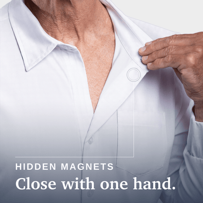 Close-up of a person wearing a white button-up shirt, with one hand pulling the collar slightly open. Text on the image reads 'HIDDEN MAGNETS Close with one hand. Joe & Bella Magnetic Button-Down for Men | Relaxed-Fit #White