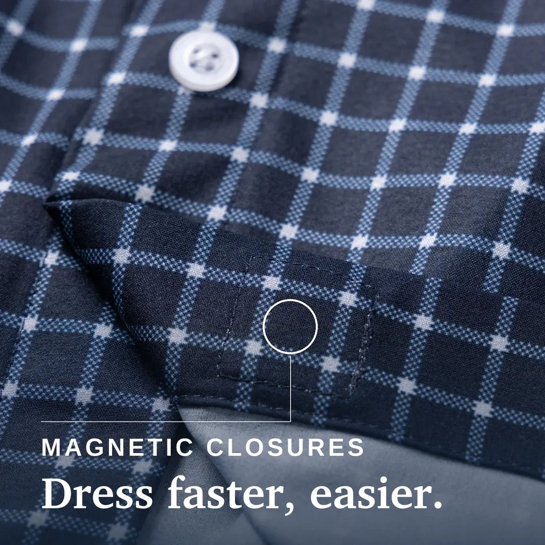 Close-up of a navy and light blue plaid shirt fabric with a white button and text reading 'MAGNETIC CLOSURES Dress faster, easier.'. Joe & Bella Everyday Magnetic Button-Down for Men | Relaxed-Fit #Navy Check