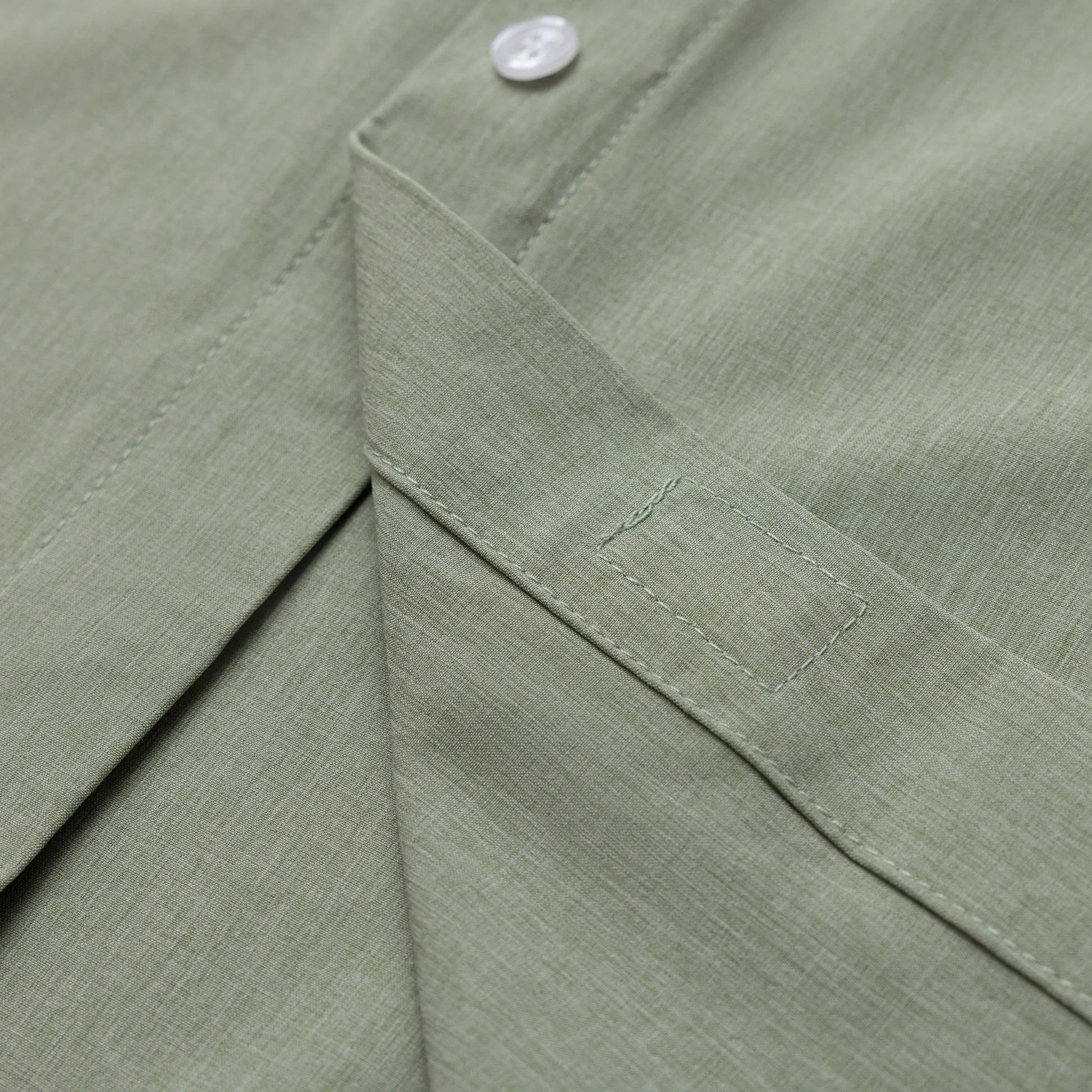 ["Close-up of a green fabric with a button detail ", "Green"]