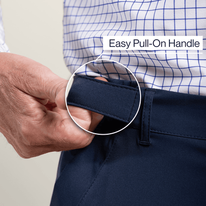 Person adjusting navy pants with an easy pull-on handle, wearing a checkered shirt. #Navy