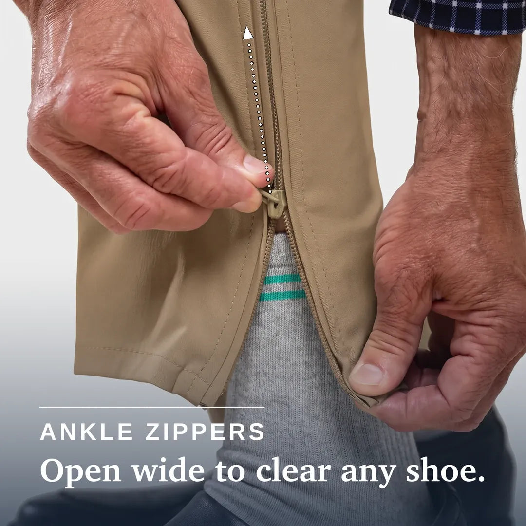 Close-up of a person's hands demonstrating an ankle zipper on a tan garment, with text reading 'ANKLE ZIPPERS Open wide to clear any shoe.'. Joe & Bella Signature Side-Zip Chinos for Men #Khaki
