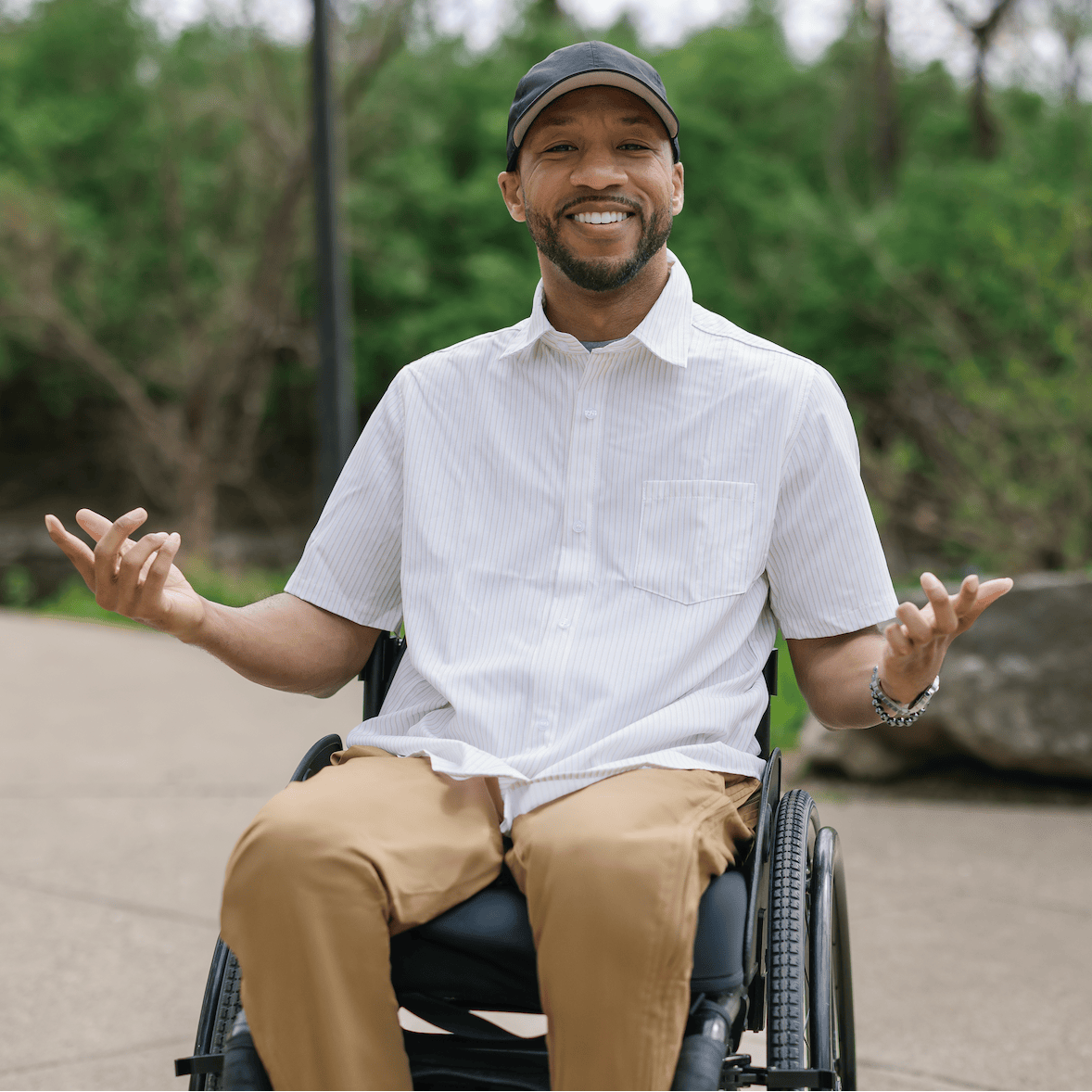 Man in a wheelchair sitting outdoors with nature in the background #Tan Stripe