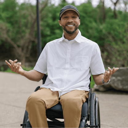 Man in a wheelchair sitting outdoors with nature in the background #Tan Stripe